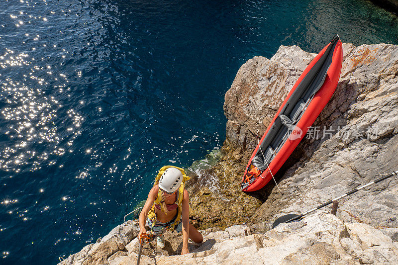 费拉塔岛(Via Ferrata)上的攀登者，年轻的妇女们在攀登海面上的岩石